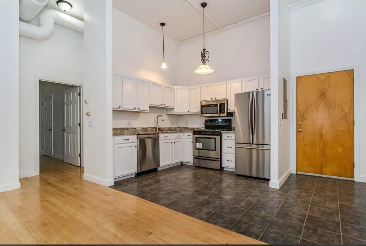 Example Foster Place kitchen with white cabinets and stainless steel appliances
