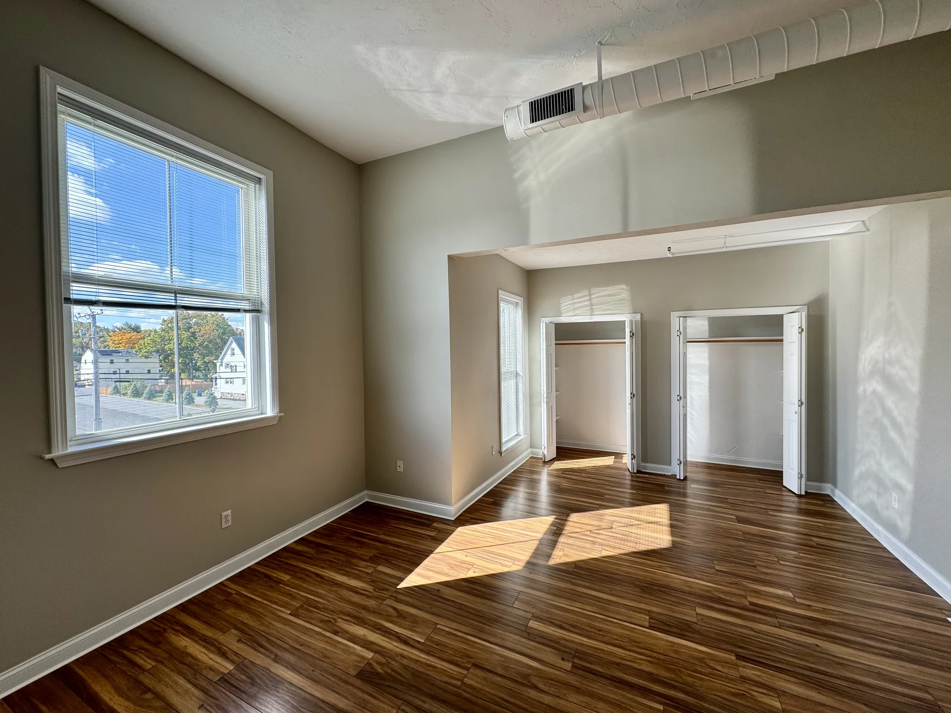 Bright apartment room with closets and tall windows